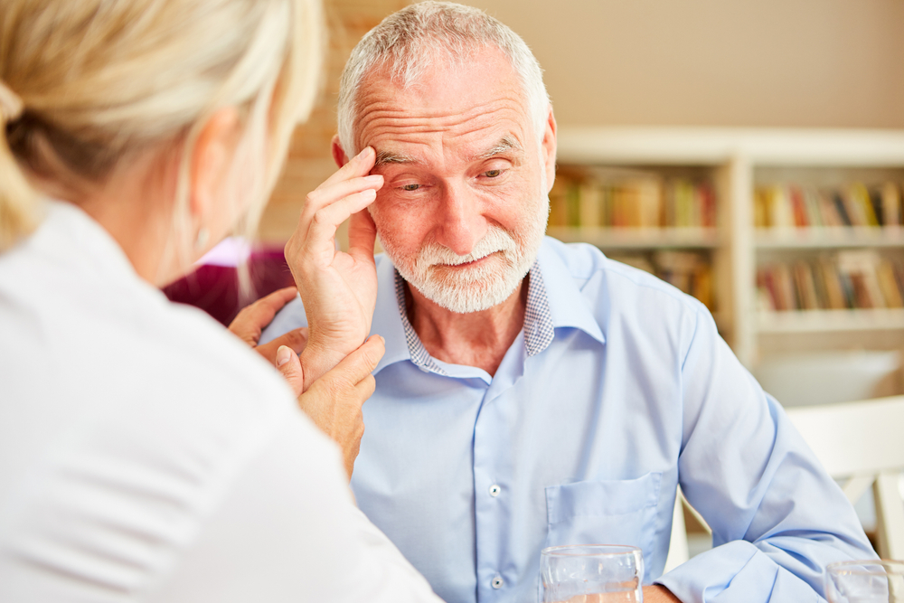 Elderly individual speaking with a caregiver about cognitive concerns, illustrating cases handled by a Lakewood will contests attorney.